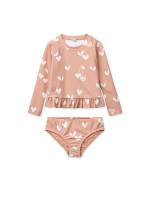 Badedrakt i ferskenfarge med langermet topp med hvite hjerte-mønstre og volangkant, matchende bikinibund med lignende mønster.