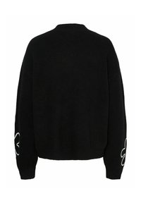 Pull noir en tricot avec un design boxy, des manches larges et une broderie florale blanche sur la manche gauche. Texture douce avec des poignets côtelés.