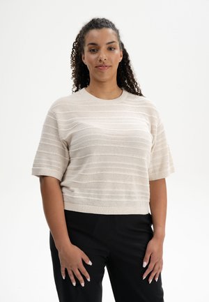 Helle beige gestrickte Bluse mit kurzen Ärmeln, mit horizontalen Streifen und einem gerippten Kragen, kombiniert mit schwarzen Hosen.
