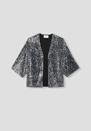 Veste ornée de sequins en argent et noir, présentant une coupe ample, un col en V et de larges manches pour une silhouette décontractée.