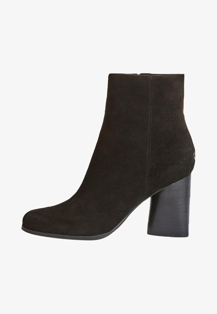 Botte de cheville en suède noir avec un bout arrondi, un haut talon bloc et des détails de couture minimalistes. Texture lisse et silhouette élégante.