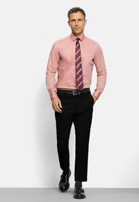 Herren Hemd in Hellrosa mit Streifen, kombiniert mit schwarzen Hosen und schwarzen Schuhen. Das Outfit enthält eine gestreifte Krawatte in dunklen Farben.