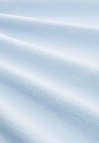 Tetier albastru deschis cu o textură subtilă, prezentând pliuri moi și fluide și o suprafață netedă, potrivită pentru diverse aplicații textile.