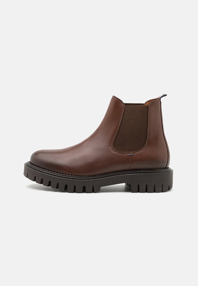 Botte Chelsea en cuir marron avec panneau latéral élastique et semelle épaisse à crampons sur fond blanc.