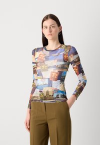 Camicia a maniche lunghe con un collage di stampe a tema viaggio in blu, giallo e marrone. Realizzata in un tessuto elasticizzato e morbido.