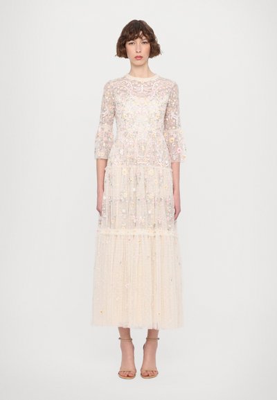 Maxikjole i gennemsigtigt, broderet stof med blomster mønstre. Har trekvartærmer og lagdelt tylkant i blød beige.