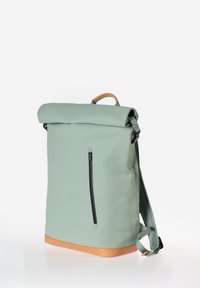Zaino verde a roll-top con una texture liscia, dotato di una tasca frontale con zip, dettagli beige e spallacci regolabili per una comodità di trasporto.