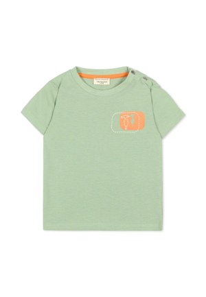 Maglietta verde chiaro a maniche corte per bambino con dettaglio arancione sul collo, due bottoni a pressione sulle spalle e una piccola toppa arancione con design di cactus e pala.