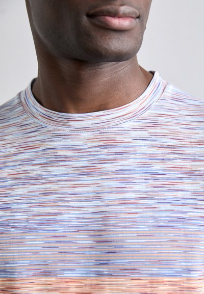 T-shirt à manches courtes avec un col rond, présentant un motif rayé multicolore dans des teintes pastel de bleu, orange et violet.