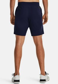 Bermudas deportivas de color azul marino con cintura plana y bolsillos laterales, hechas de una tela ligera. Presentan una textura suave y un corte regular.