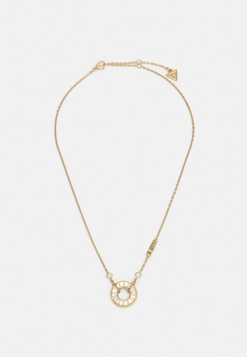 Collier délicat en chaîne d'or avec pendentif circulaire gravé "GUESS" et deux petites pierres précieuses transparentes de chaque côté.