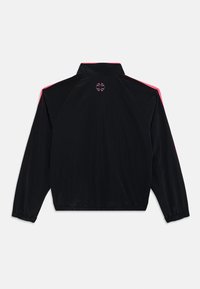 Casaco preto com gola alta, apresentando riscas de destaque rosa nos ombros e um pequeno logótipo na parte superior das costas. Material leve.