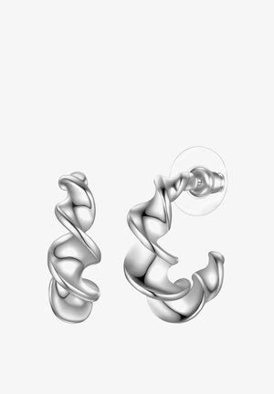 Korvakorut, joissa on kiiltävä hopeametalli ja kiemurteleva, veistoksellinen muotoilu, jossa on sileät pinnat. Kaksi osaa: nappikorvakoru ja suurempi rengas.