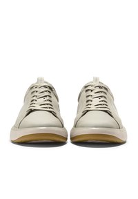 Hnědé sportovní boty s hladkým koženým svrškem, síťovinovými panely a kulatými tkaničkami. Podešev je světlá s texturovanou gumovou podrážkou.