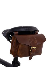 Brown leather saddlebag with buckle attached under a black bicycle seat against a white background.