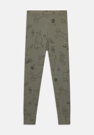 Zaļas legingi ar melniem zīmējumiem, kuros attēloti dzīvnieki un daba, tostarp lāči, lapsas un sēnes, ar gludu, elastīgu tekstūru.