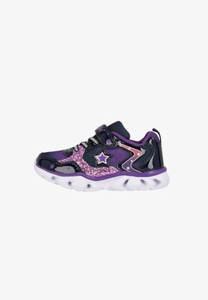 Lila Sport-Schuh mit glänzendem Material, glitzernden Akzenten, Sternmustern, einem sicheren Riemen und einer markanten, strukturierten Sohle.