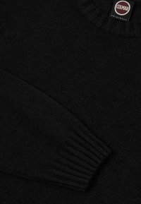 Schwarzer, gestrickter Pullover mit geripptem Halsausschnitt und Bündchen. Weiche Textur, mit einem Etikett von Colmar Originals. Schlichtes, klassisches Design.