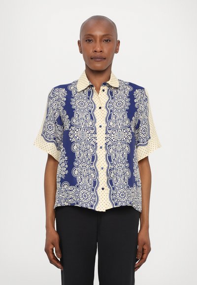 Short-sleeve shirt featuring a blue and cream paisley pattern with polka dots, buttons down the front, and a collared neckline.