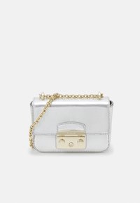 Srebrna metaliczna torebka z złotą łańcuszkową rączką, prostokątny kształt i zapięcie z przodu z logo marki oraz okrągłymi akcentami.