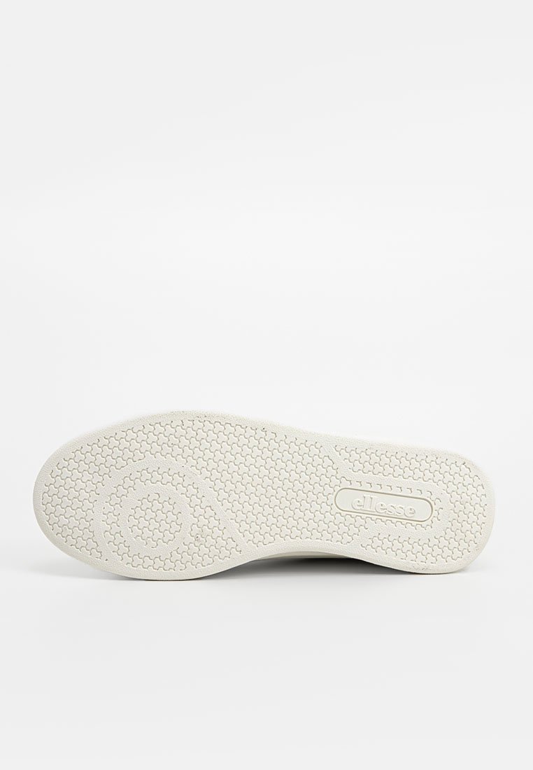 Suola di sneaker bianca con gomma testurizzata per una presa migliore. Presenta motivi circolari e esagonali, e un logo impresso sul lato.