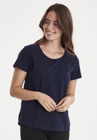 Mørkeblå bomulds-t-shirt med korte ærmer, rund halsudskæring og en afslappet pasform. Glat tekstur, enkelt design uden mønstre eller udsmykninger.