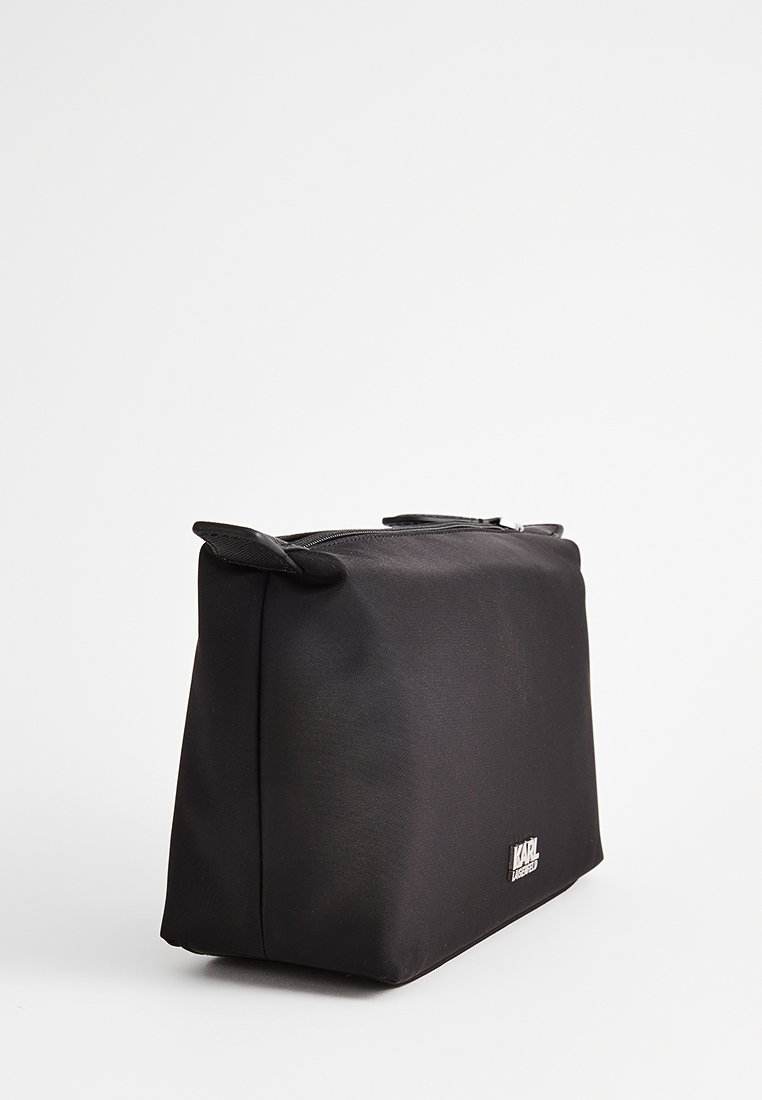 Borsa cosmetica rettangolare nera realizzata in tessuto strutturato, con zip superiore e piccole maniglie laterali per un facile trasporto.