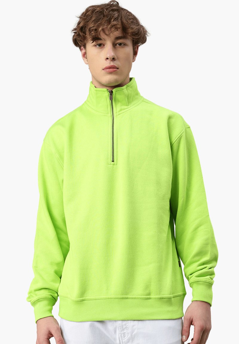 Limegrüner Pullover mit hohem Kragen, Viertelreißverschluss und gerippten Bündchen. Hergestellt aus weichem Stoff mit lässiger Passform.