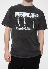 Black graphic t-shirt made of soft cotton with a faded texture. Features a band print of five figures and "Good Charlotte" in bold white lettering.