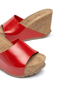 Red patent leather wedge sandals with cork platform, open toe, wide strap, and textured footbed. Flexible rubber sole with grips.