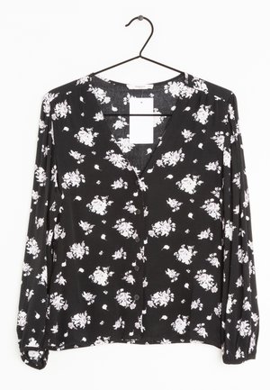 Czarna bluzka z długim rękawem, w drobny różowy wzór kwiatowy, z guzikami z przodu i dekoltem w kształcie litery V. Miękka tekstura, z bufkami na rękawach i luźnym krojem.