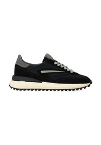 Sneaker nera e grigia con tomaia in suede e tessuto, caratterizzata da uno strato testurizzato, lacci grigio chiaro e una spessa suola in gomma bianca.