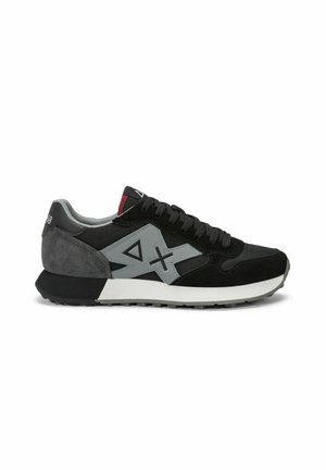 Scarpa sportiva nera e grigia con suola bianca, logo geometrico grigio sul lato, lacci neri e dettaglio rosso sulla linguetta.