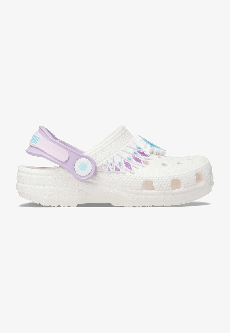 Sabot blanc avec un design texturé, orné d'une sangle et d'accents lavande. Perforations pour une meilleure respirabilité. Matériau léger et flexible.