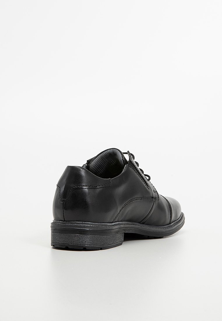 Soulier en cuir noir avec une surface lisse, design à lacets, bout arrondi et semelle en caoutchouc à profil bas. Vue arrière, montrant les détails de couture.