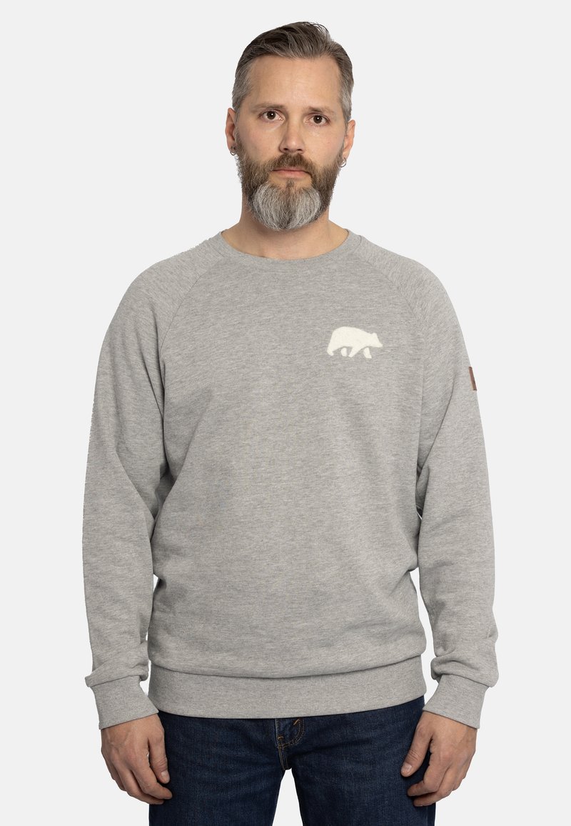 Felpa grigia realizzata in morbido tessuto, con una grafica di un orso bianco sul petto e polsini e orlo a coste. Abbinata a jeans in denim scuro.