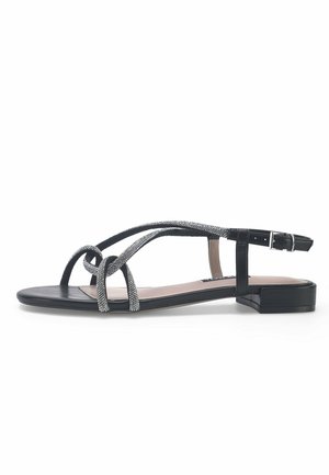 Black flat sandals with a cross strap design, embellished with silver rhinestones, featuring a slim ankle strap and a low block heel.