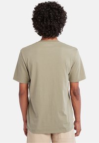 Kortærmet t-shirt i olivengrøn, lavet af blødt bomuld. Klassisk crew neck design med dobbeltstikning i kanten og minimal branding på siden.