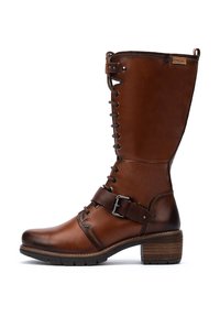 Botte en cuir marron haute avec des lacets, une sangle au niveau de la cheville avec une boucle en métal, un petit talon empilé et une semelle en caoutchouc, marquée "Pikolinos" près du bord supérieur.