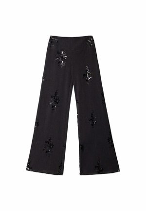 Pantalones anchos negros con sutiles patrones de lentejuelas florales dispersos por la tela sobre un fondo blanco liso.