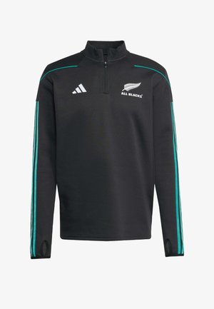 Svart idrottspuller med en kvartdragkedja, turkosa ränder på ärmarna och "All Blacks"-logotypen tydligt visad på bröstet.