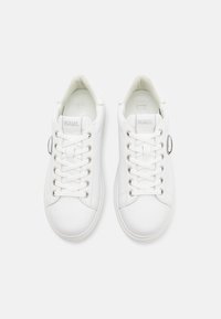 Baskets blanches avec tige en cuir lisse, bout rond, lacets plats blancs, œillets argentés et logo KARL sur la languette et le côté.