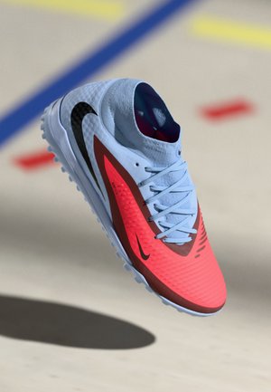 Nike atletska cipela s svijetloplavam gornjištem, svijetlocrvenim detaljima, teksturiranim uzorkom, crnim logotipom i laganim potplatom s malim noktima.