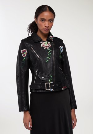 Giacca da motociclista nera in pelle con ricami floreali in rosso, blu e verde. Include una vita con cintura, cerniere e tasche laterali.