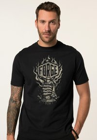 Sort bomulds t-shirt med et grafisk design af en stiliseret hånd, der griber fat om et skilt med "FORGE & SONS" og flammer, vintage æstetik.