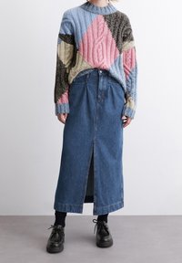 Stickad tröja med olika färgade diamantmönster i blått, rosa, brunt och kräm, i kombination med en lång denimkjol med sprund fram.