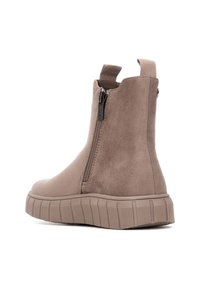 Botas de ante taupe hasta el tobillo con cremallera lateral, suela de goma texturizada y un tirador en la parte posterior para facilitar el calzado. Diseño elegante y moderno.