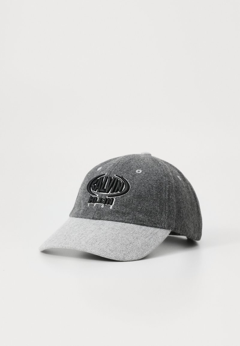 Grå uldhat med en lys grå skygge, der har et sort broderet logo og dato. Den har et struktureret design og seks ventilationshuller.