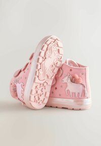 Rózsaszín anyagú, magas szárú cipők unikornis és csillagmintázattal, tépőzáras pántokkal, texturált talppal és pompon részletekkel.