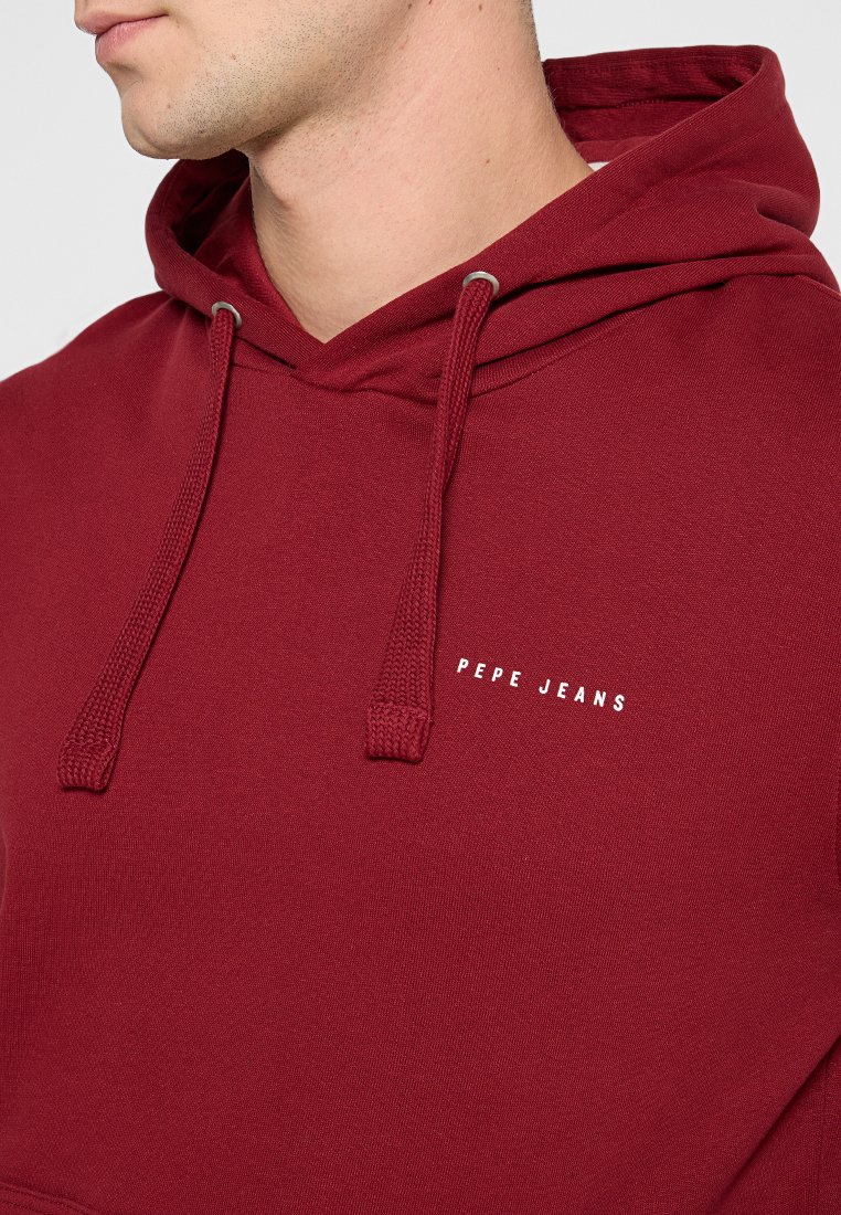Sudadera color burdeos con cordones, que presenta el texto "PEPE JEANS" en blanco. Tela de sudadera con una textura suave y bolsillo tipo canguro.
